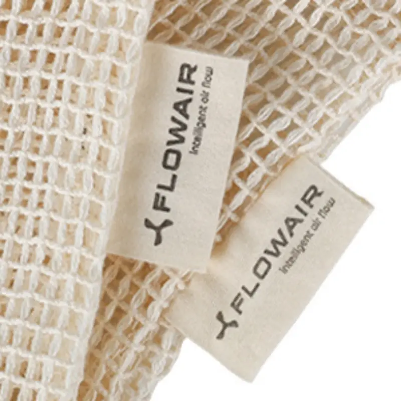Close-up image of a woven label on the side of a cotton mesh bag, showcasing where logos can be printed and sewn.