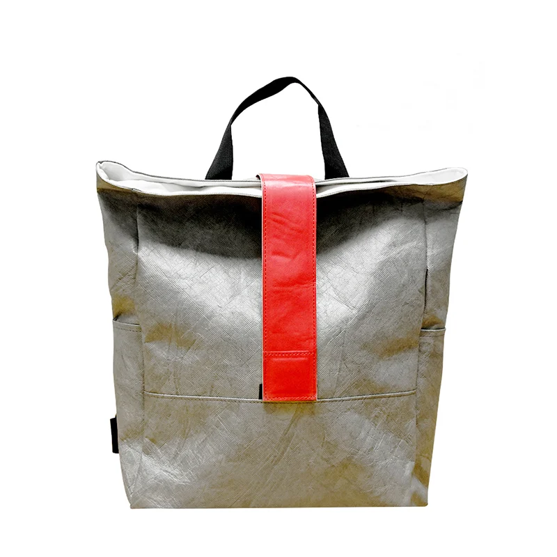 A dark green DuPont paper (Tyvek) backpack with a large front pocket, two side pockets, and a Velcro closure