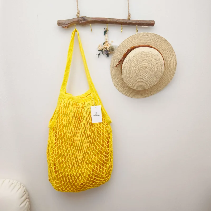 Image of a yellow cotton mesh bag with a polyester lining, highlighting its vibrant color, durable design, and versatility