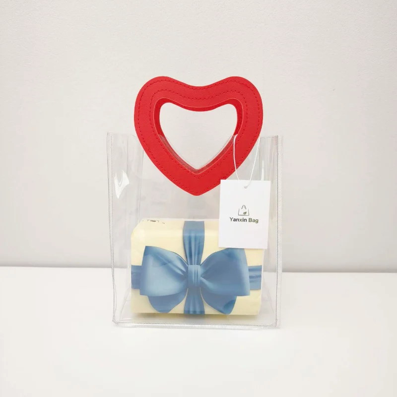 The Best Hotsale Wholesale Custom Clear Bag Styles in 2025 3 Image of a transparent PVC bag with heart-shaped leather handles, showcasing its customizable features in terms of material, color, size, printing, and handle shapes