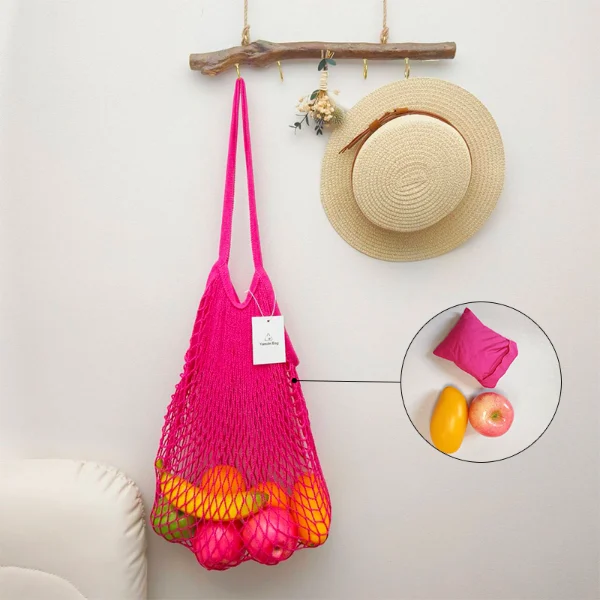 red cotton mesh bag filled with fruits hanging on wall shown in How to Effectively Care for Reusable Cotton Mesh Bags