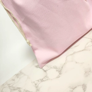 Reinforced bottom corner of a custom drawstring bag showing stitching, eyelet, and material strength