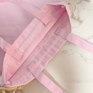 Close-up of drawstring and handle on a custom drawstring bag, highlighting cord thickness and stitching quality