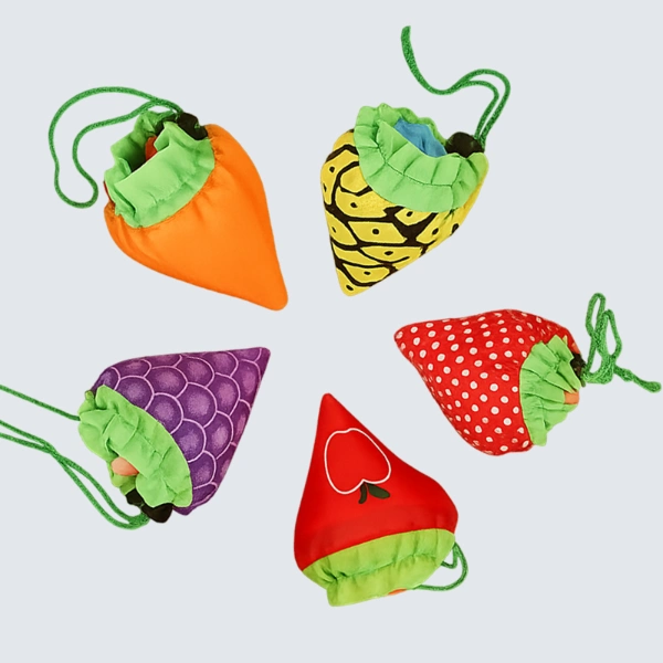 Top view of five colorful foldable bags in fruit and vegetable shapes including carrot, pineapple, strawberry, grape, and apple, customizable in size, material, style, and printing.