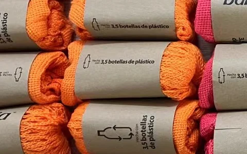 Folded cotton mesh bags wrapped with custom paper sleeves for branding