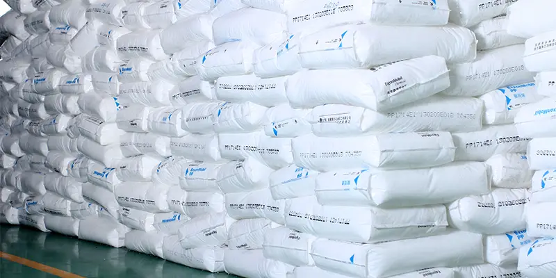 polypropylene raw material bags stacked in warehouse shown in What Is PP Spunbond Nonwoven Fabric