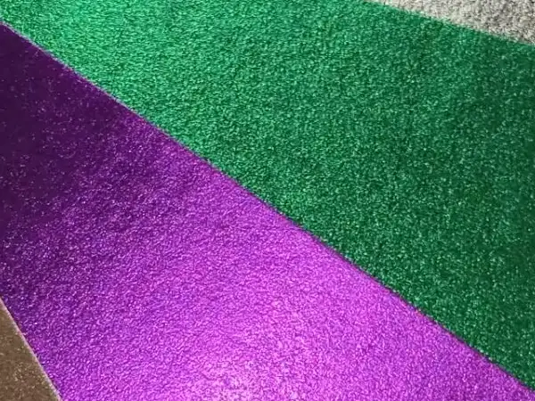 A close-up view of washable kraft paper featuring a metallic laminated surface with vibrant green and purple reflective textures.