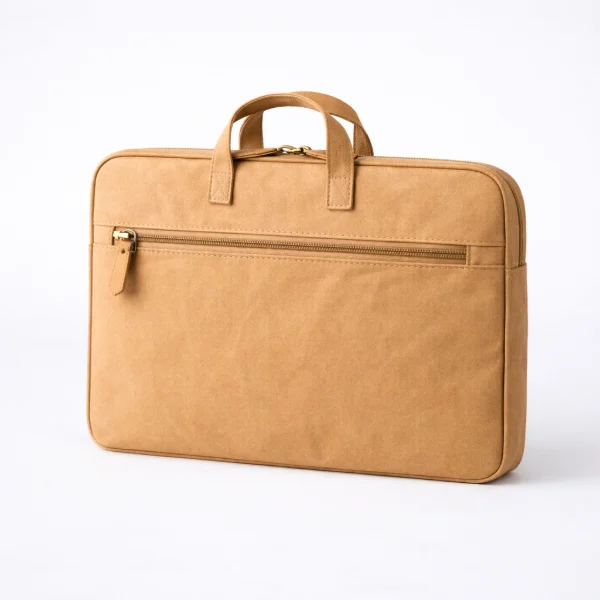 A minimalist washable kraft laptop bag with short carrying handles and a zippered compartment on a light background.