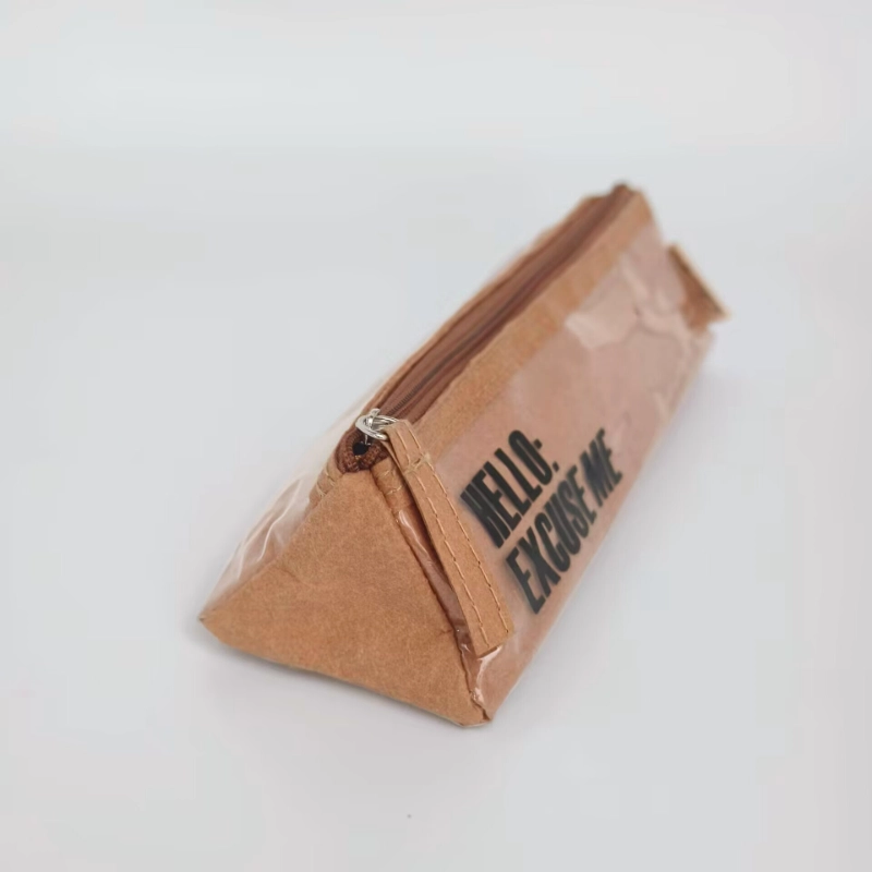 A triangular washable kraft pencil case with a zipper closure and a partially transparent outer layer on a clean background.