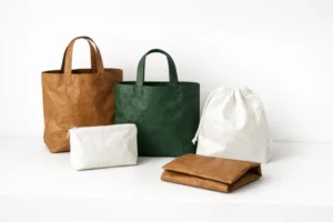 A group of bags in different shapes and colors made from Tyvek material, including tote bags, a drawstring pouch, a zipper pouch, and a folded pouch.