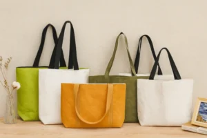 Five structured tote bags in different colors displayed on a wooden table, showcasing common Tyvek bag styles on the market.