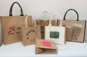 A group of reusable tote bags with different printed designs arranged together, showing why businesses choose jute bags for packaging and promotions.