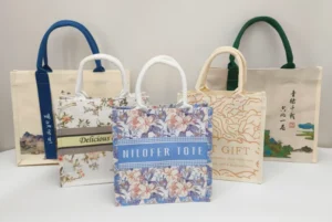 Several printed canvas tote bags with different finishes, illustrating Why Are Coated Canvas Bags More Expensive Than Regular Canvas Bags.