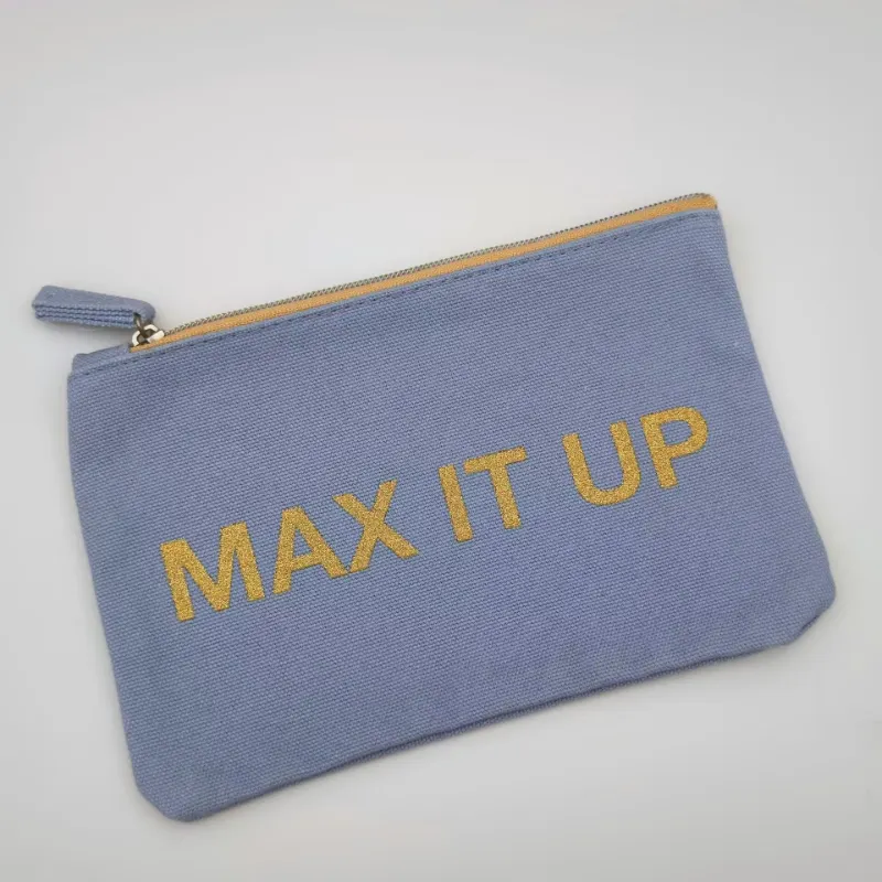 A flat canvas cosmetic pouch with zipper and gold printed design used for storing makeup and small essentials