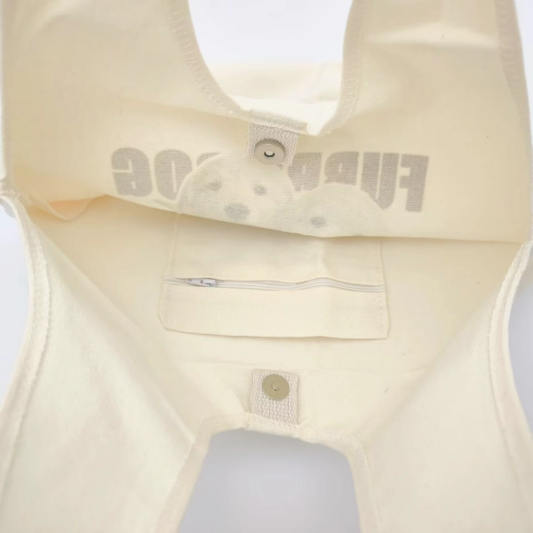 Internal view of a magnetic snap closure used in a tote bag, showing hidden fastening components inside the fabric layers.