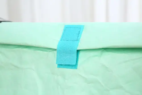 Close-up view of a roll top bag closure using a Velcro strap to secure the folded opening.