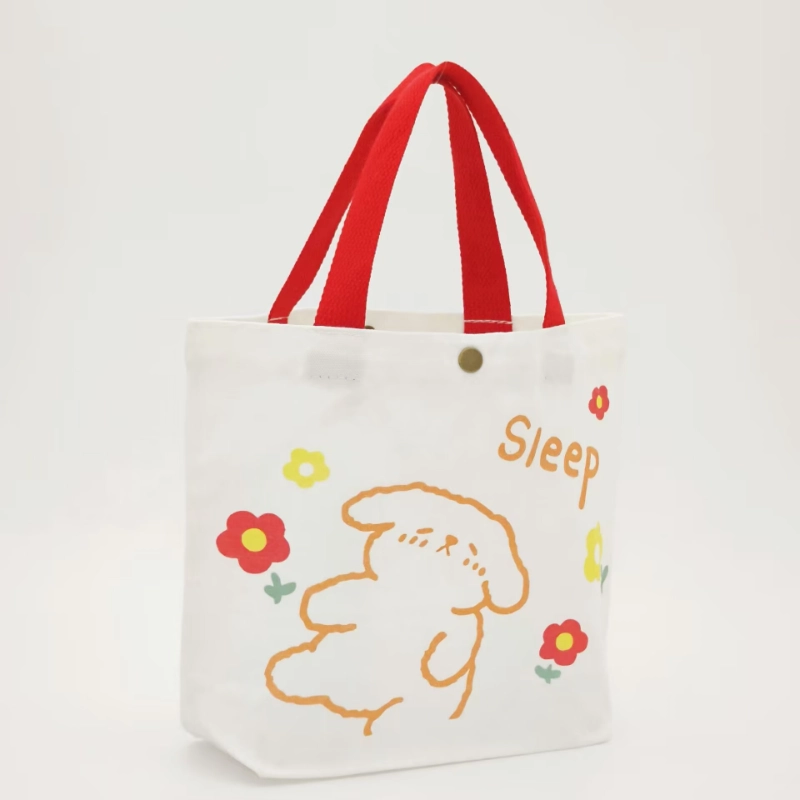 Canvas tote bag featuring a snap button closure at the top opening with printed graphic design.