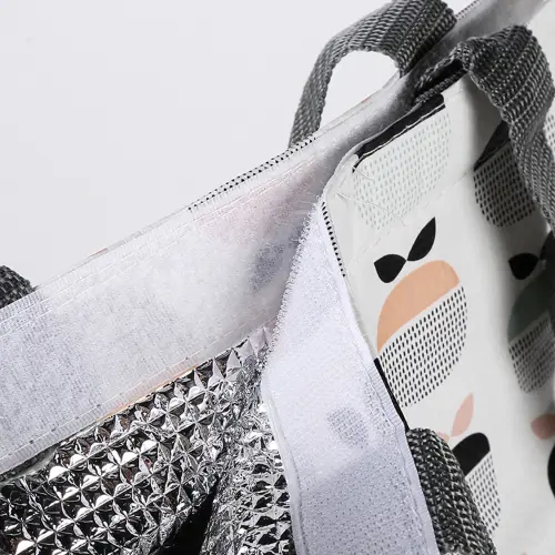 Close-up of a tote bag showing Velcro closure area and insulated thermal inner lining with multi-layer structure.