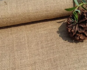 What Is Burlap Fabric? A natural burlap fabric roll is shown with a coarse woven texture and rustic surface.