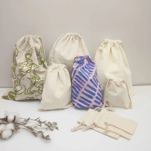 Various sizes of cotton drawstring bags displayed together, shown in the Choosing the Best Custom Drawstring Bags guide