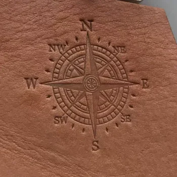 Embossed leather logo showing a detailed compass design