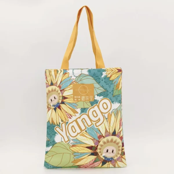 Full color printed canvas tote bag with vibrant sunflower design and yellow handles, front view, customizable in size, material, style, and printing.